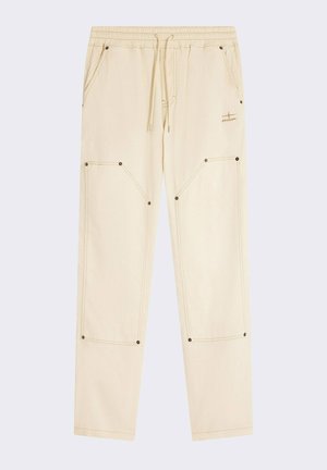 Pantaloni jogger color crema con vita elastica, cordino, due ampie tasche laterali e dettagli in cucitura a contrasto.