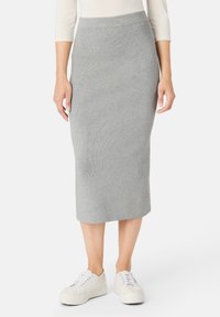 Šedá žebrovaná midi sukně z elastického pleteného materiálu, s přiléhavým střihem a pasem, zkombinovaná s bílými teniskami.