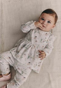 Conjunto para bebé con estampado floral en suave color rosa, con mangas fruncidas y puños elásticos, confeccionado con tela ligera, combinado con calzado rosa.