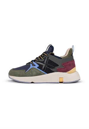 Multicolored sneaker featuring a mesh and suede upper in navy, green, and burgundy, with a thick cream sole and textured detailing.