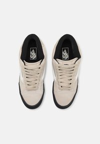 Beige sneakers i suede og tekstil med hvite detaljer. Rund tå, svart gummisåle og beige snøringer. Logo på innersålen og siden.