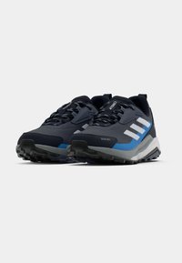 Navy and gray athletic shoes with a textured upper, reinforced accents, patterned laces, and a rugged outsole for traction.
