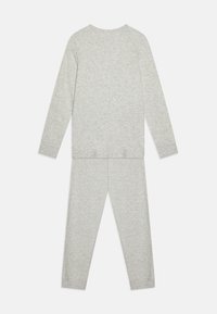 Grijze lang mouwtop en bijpassende broek gemaakt van zachte, rekbare stof. Eenvoudig ontwerp, geen patronen of versieringen.