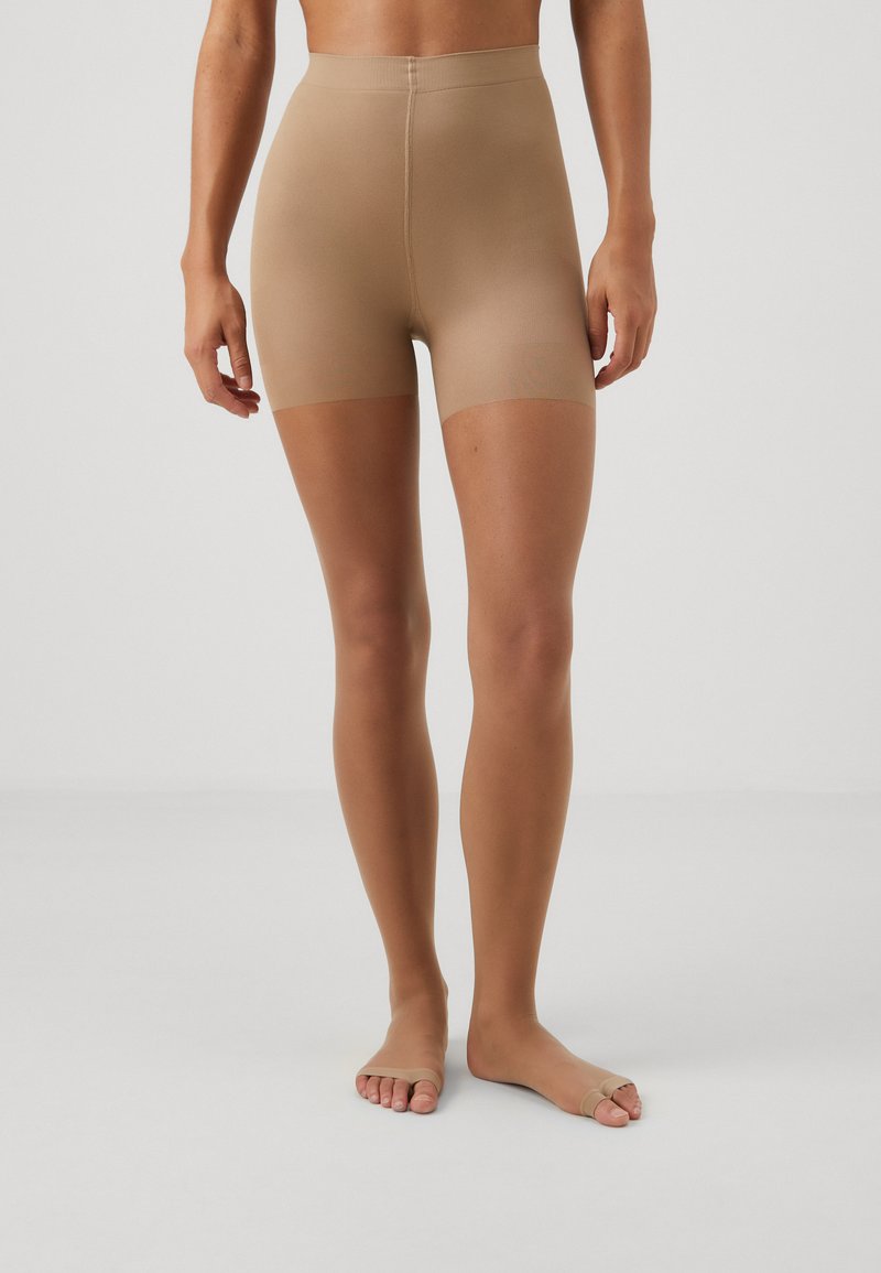 Beige seamless high-waisted shorts with a smooth texture, short length, and open toe design, suitable for layering under clothing.