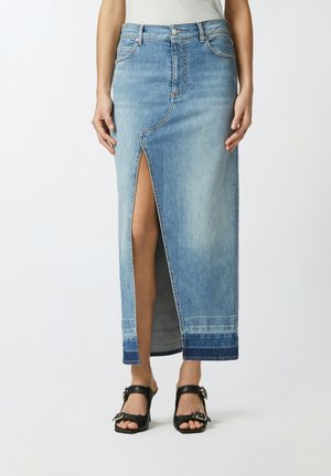 Jupe maxi en denim bleu clair avec fente frontale, taille haute et ourlet inférieur en contraste. Comprend des coutures classiques et des poches avant.