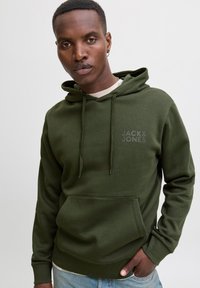 Green hoodie made of soft fabric, featuring a front pocket, adjustable drawstrings, and a discreet logo on the chest.