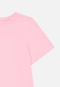 Camiseta de manga corta en suave algodón rosa claro. Presenta un escote redondo y una textura lisa con costuras limpias.