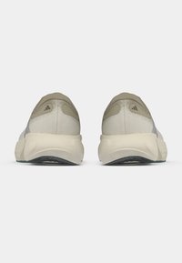 Αθλητικά παπούτσια ανοιχτό γκρι με υφή πλεκτού στο επάνω μέρος, στρογγυλεμένο σχήμα και μπεζ μεσαία σόλα. Διαθέτουν διακριτικές πράσινες λεπτομέρειες και μαύρη εξωτερική σόλα.