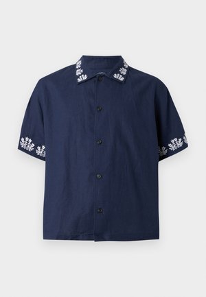 Mørkeblå kortermet skjorte med knapper, hvit blomsterbroderi på krage og ermekanter, ensfarget foran og svarte knapper.