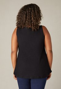 Svart ärmlös topp tillverkad av mjukt tyg, med avslappnad passform och rundad nederkant. Inga synliga mönster eller hårdvarupynt.