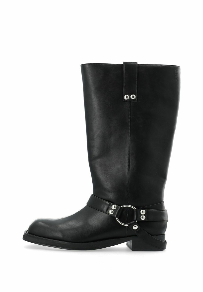 Botas de cuero negro hasta la rodilla con una forma ancha, una correa con un acento metálico circular y un tacón bajo con una suela texturizada.