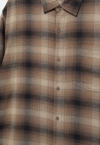 Brązowo-czarna koszula w kratę z guzikami, kołnierzykiem i kieszenią na piersi, z gradientowym przejściem wzoru.