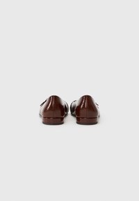 Brune lakk lær sko med en glatt overflate, slank form og minimalistisk design, med flat hæl og uten utsmykninger.