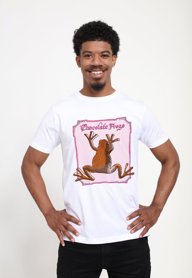 Biała bawełniana koszulka z ilustracją brązowej żaby, z akcentami w kolorze różowym i fioletowym oraz napisem "Czekoladowe Żaby."