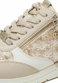 Smėlio spalvos sportinė avalynė su gėlių audiniu, tekstūruota oda, auksinėmis detalėmis ir pintomis raištelėmis; šone yra užtrauktukas patogiam naudojimui.