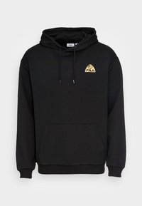 Sudadera negra con capucha ajustable, bolsillo frontal y un logo triangular bordado en dorado. Fabricada con un tejido suave y con puños acanalados.