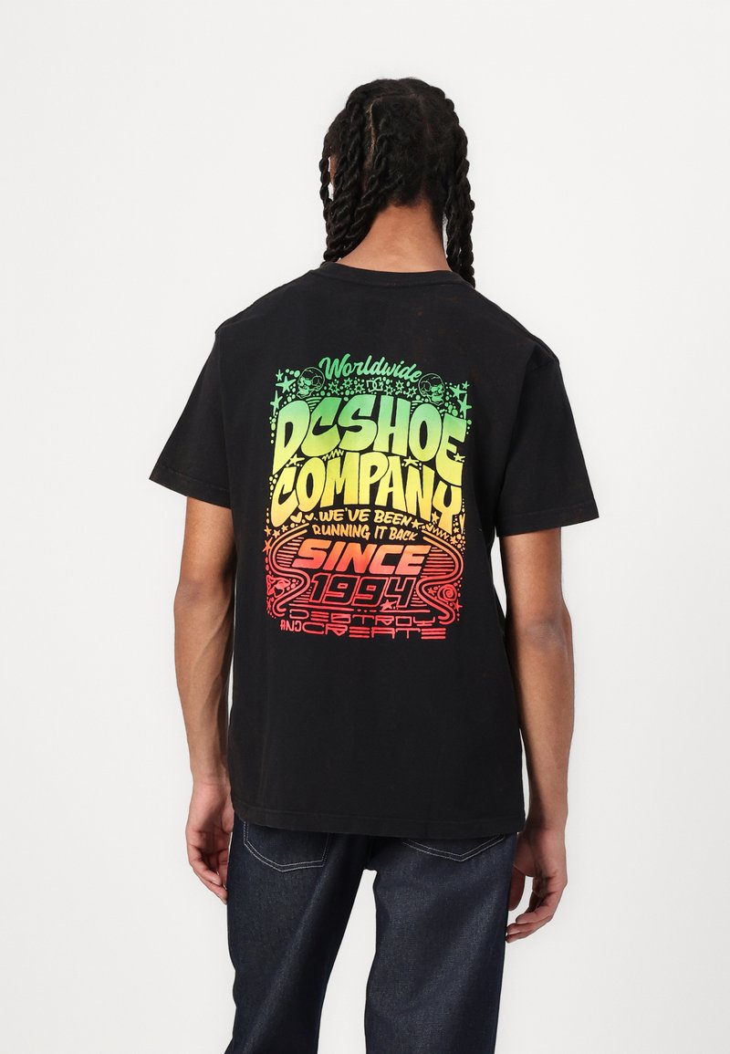 Black cotton t-shirt featuring a multicolored graphic print on the back with text and star patterns, short sleeves, and a relaxed fit.