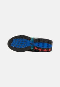 Podošva topánky Nike s textúrovanou čiernou gumou, modrými a červenými akcentmi a mnohofarebným dizajnom. Vzor obsahuje geometrické tvary.