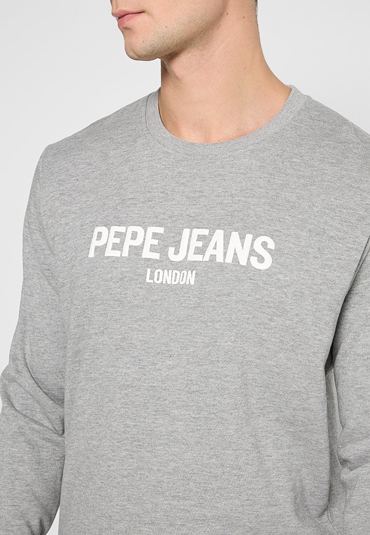 Camisa de manga larga gris de tejido suave con el texto blanco "PEPE JEANS LONDON" a lo largo del pecho, escote redondo y corte relajado.