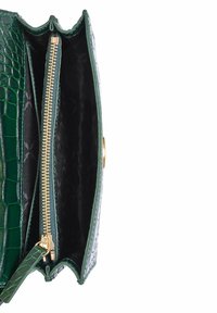 Zielona torebka z wytłoczonym motywem krokodyla, z zamkiem błyskawicznym. Posiada złote akcenty oraz teksturowane czarne wnętrze. Smukły, prostokątny kształt.