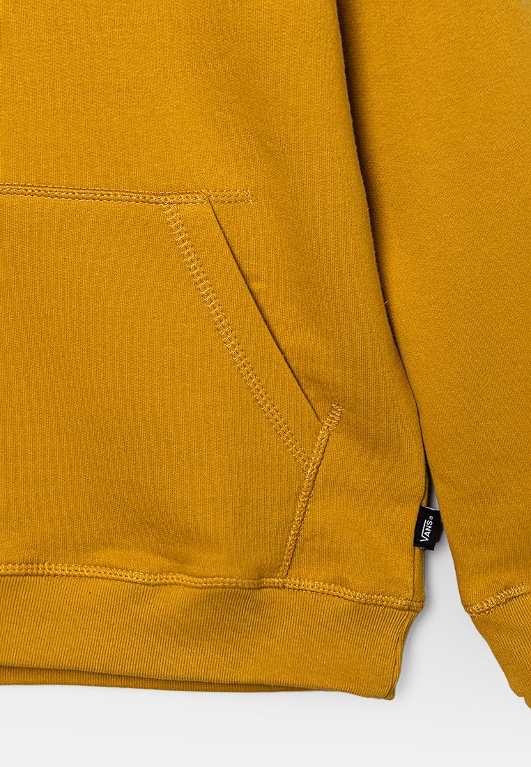 Sudadera de algodón amarilla con un bolsillo frontal, puños acanalados y una etiqueta en el dobladillo que detalla el nombre de la marca. Textura suave con acentos cosidos.