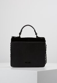 Czarna torebka z gładkiej skóry, uchwytem od góry i łańcuszkowymi dodatkami po bokach. Prostokątny kształt o wyraźnej strukturze.