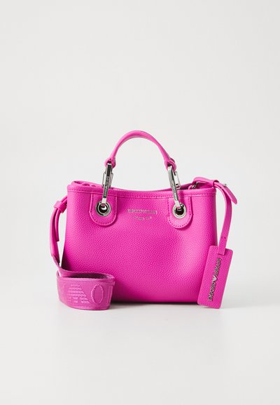 Felroze leren handtas met bovenhandgreep, gemerkte metalen details, verstelbare schouderriem en Emporio Armani-label tegen een witte achtergrond.