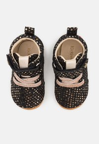 Bottes noires pour enfants ornées d'un motif d'étoiles, avec un dessus en texture douce, un bout rond, des lacets beiges, et une semelle en caoutchouc beige.