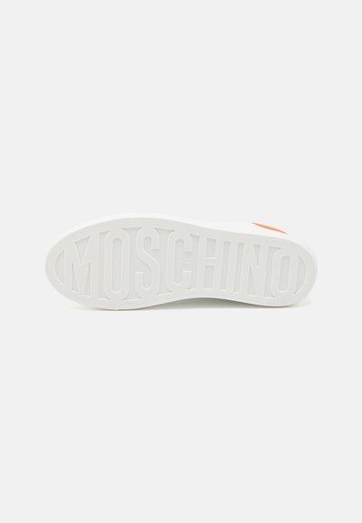 Valkoinen lenkkaripohja, jossa on kohokuvioitu "MOSCHINO"-logo, tekstuuripinta, oranssi yksityiskohta ja pyöreä varpaan muoto.