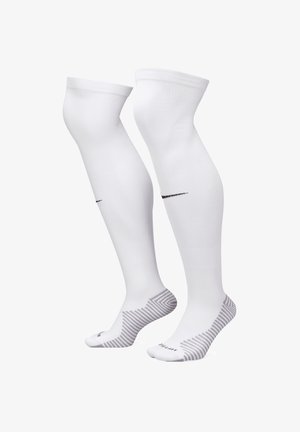 Weiße knielange Socken aus glattem Material, mit einem schwarzen Nike-Logo und einem gestreiften Muster an der Sohle.