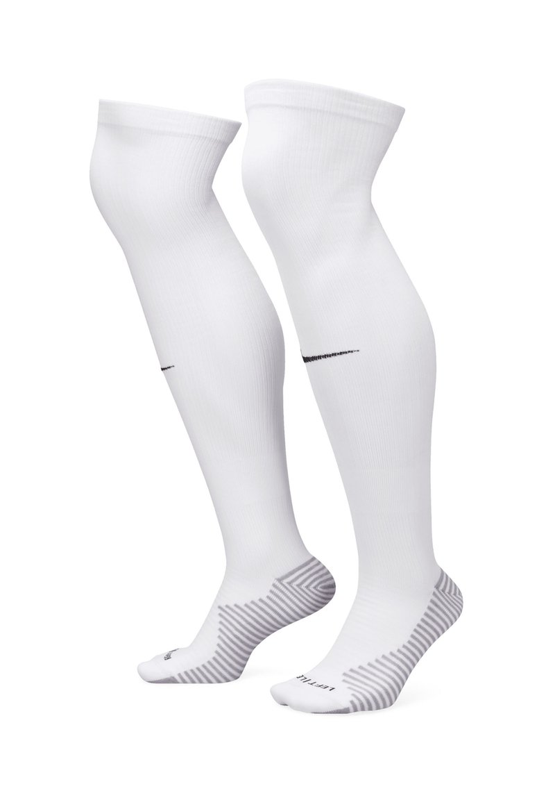 Witte kniekousen van glad materiaal, met een zwart Nike-logo en een gestreept patroon op de zool.
