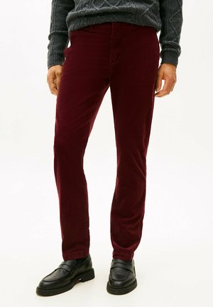Bordeaux corduroy pantalon met een slim fit, voorzien van voorzakken en een lage taille, gecombineerd met zwarte instappers.