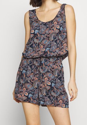 Robe combinaison sans manches bleu marine avec imprimé paisley multicolore portée par une personne debout, coupée juste au-dessus des genoux.