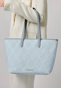 Borsa tote blu chiaro con superficie pattern e manici sintetici grigi. Presenta un logo dorato sul davanti. Design strutturato e interni spaziosi.