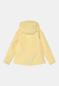 Chaqueta amarilla ligera con capucha, puños elásticos y un parche de logo en la parte trasera. Textura suave y diseño sencillo, adecuada para uso casual.