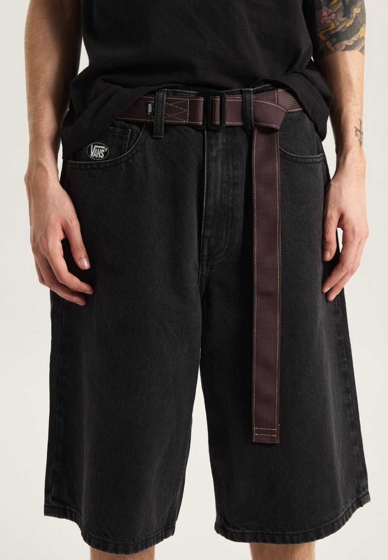 Pantalones cortos de mezclilla negra con un ajuste relajado, que cuentan con un cinturón marrón tejido, bolsillos delanteros y detalles con costuras. Logotipo de Vans en el bolsillo izquierdo.