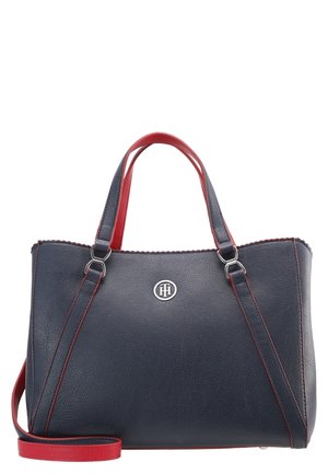 Granatowa skórzana torebka z czerwonymi uchwytami i wykończeniem, srebrnym logo na przedzie oraz regulowanym paskiem na ramię.