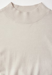 Beige gerippter Pullover mit hohem, strukturiertem Kragen. Weiches Material mit glatter Oberfläche, das ein einfaches, nahtloses Design aufweist.