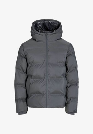 Hall kapuutsiga puffer-jakk, tumesinistest lõngast kudum, mustad püksid ja beežid jalanõud. Omadused hõlmavad lukuga esiosa ja vastupidavat tekstuuri.