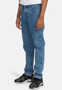 Lichtblauwe denim jeans met een ontspannen pasvorm, voorzien van vijf-pocket styling en een rechte pijpdesign. Draag ze met zwarte sportschoenen.