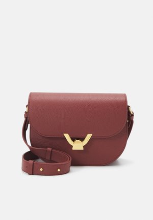 Sac en cuir bordeaux à bandoulière avec un fermoir doré, de forme arrondie, avec une sangle réglable et une surface texturée.