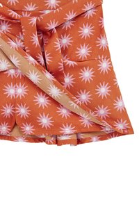 Narancssárga anyag, pink és fehér csillagformákkal. A design klasszikus, texturált felületű, derékban megkötő részletekkel.
