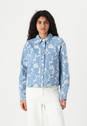 Light blue denim jacket featuring white floral embroidery, a collared neck, front button closure, and a single chest pocket.