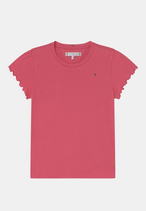 Różowa bawełniana koszulka z falbanowymi krótkimi rękawami, okrągłym dekoltem i małym logo marki w okolicy klatki piersiowej. Gładka faktura, casualowy design.