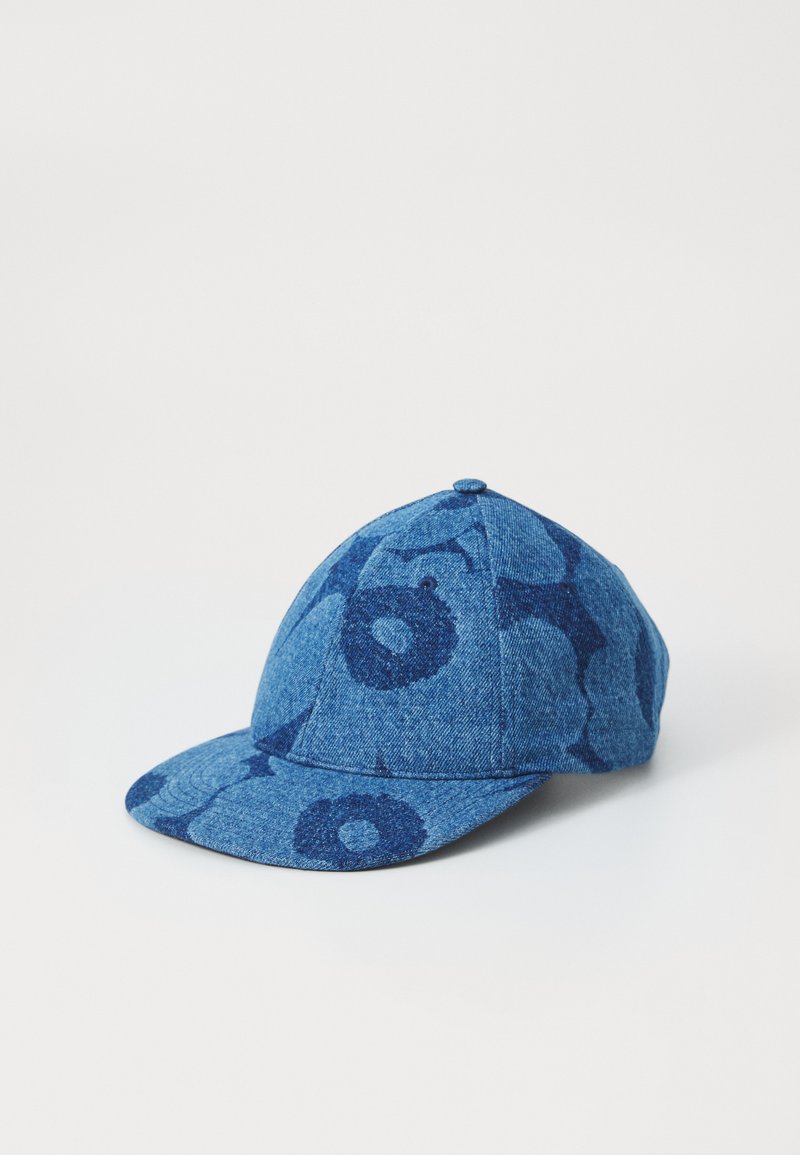 Blue denim cap featuring a patterned design. The front has a curved brim and a rounded top with visible stitching and eyelets.
