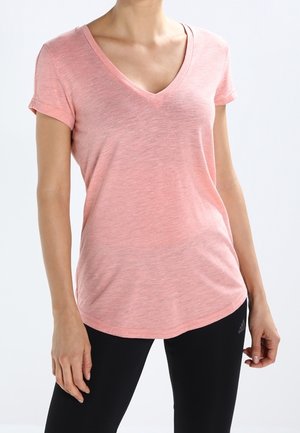 Helles rosa, kurzärmeliges V-Ausschnitt-T-Shirt aus weichem, strukturiertem Stoff. Leicht abgerundeter Saum, kombiniert mit schwarzen, figurbetonten Hosen.