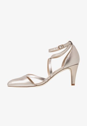 Chaussure à talon haut en cuir métallique doré avec un bout pointu et des brides croisées à la cheville. Elle présente une finition en cuir lisse et brillante et un talon de 7,5 cm.