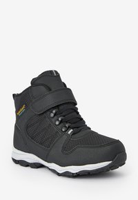 Schwarze High-Top-Sneaker aus strukturiertem Synthetikmaterial mit einem Klettverschluss, runden Schnürsenkeln und einem gemusterten Seitenpanel. Robuste Gummisohle.