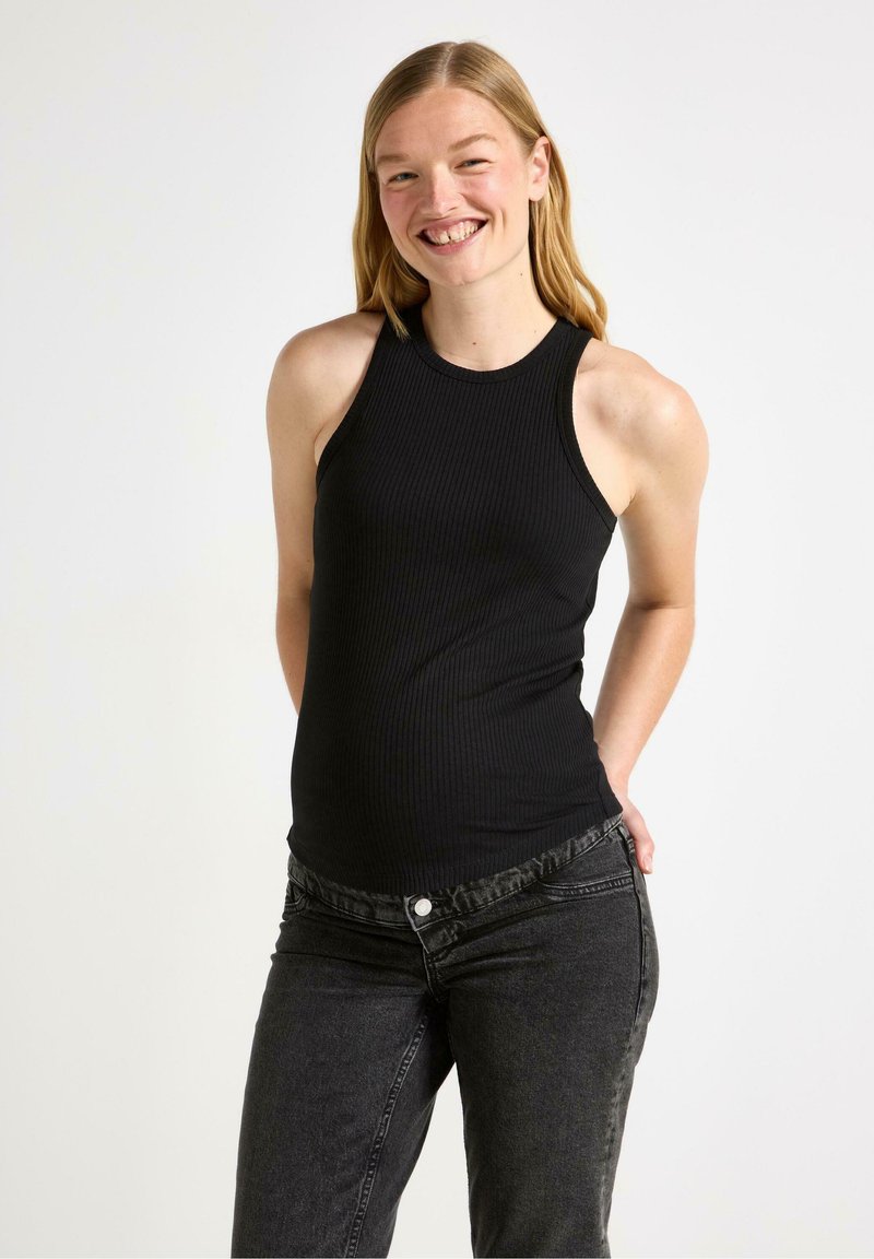 Sort ribbet tanktop med ærmeløs design, tætsiddende form og rund halsudskæring, parret med mørkegrå slim-fit jeans.