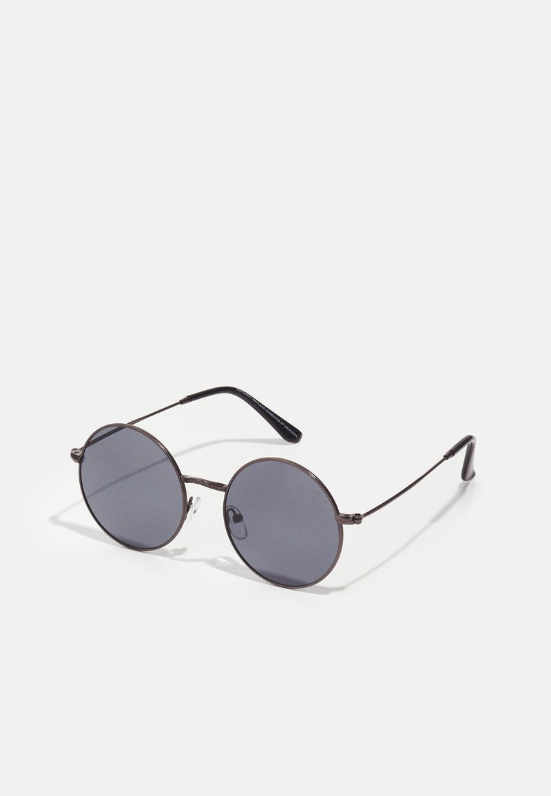 Óculos de sol redondos com lentes escuras, armações metálicas finas e pontas de templo pretas. Apresentam almofadas nasais ajustáveis para conforto.